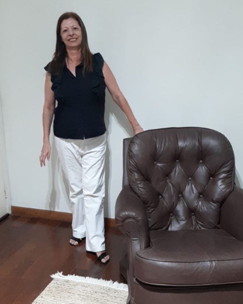 psicologa-depressao-sorocaaba Psicóloga Vera que atende em Sorocaba. Em seu consultório sorrindo ao lado da poltrona